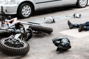 Motorcycle Accident Lawyer Coral Springs, FL with a person lying on the road next to a motorcycle that has crashed