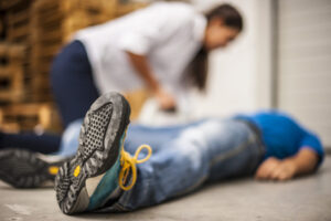 Slip And Fall Lawyer Coral Springs, FL for help with a man lying on the floor with a woman checking on him